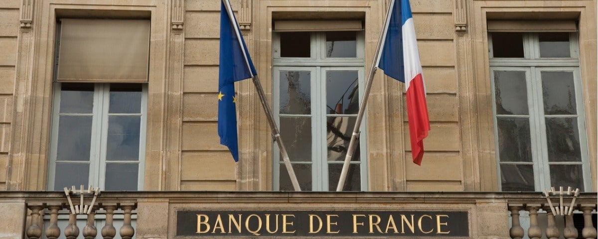 Bâtiment de la Banque de France avec drapeaux français et européens.