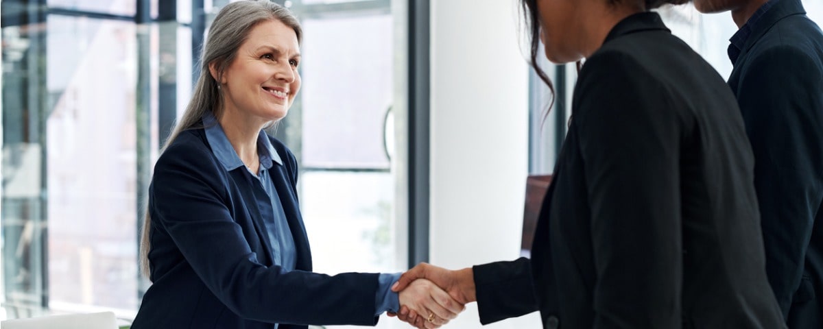 Plan d’une femme d’affaires mature serrant la main d’un collègue lors d’une réunion dans un bureau moderne