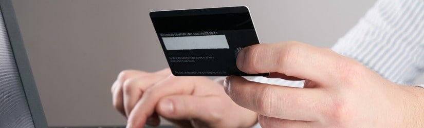 Les mains de l'homme d'affaires tiennent une carte de crédit et utilisent un ordinateur portable pour faire des achats en ligne.