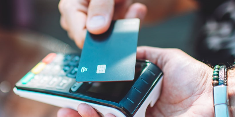 Homme adulte payant avec une carte de crédit dans un café