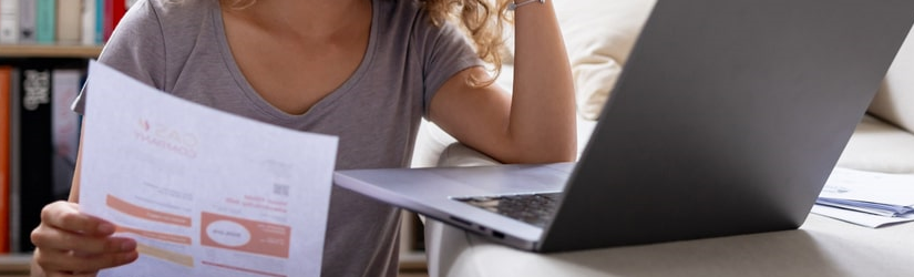 Une femme semble s'inquiéter des finances de son foyer en lisant son relevé bancaire