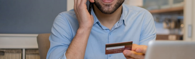 Homme faisant des achats en ligne avec une carte de crédit.