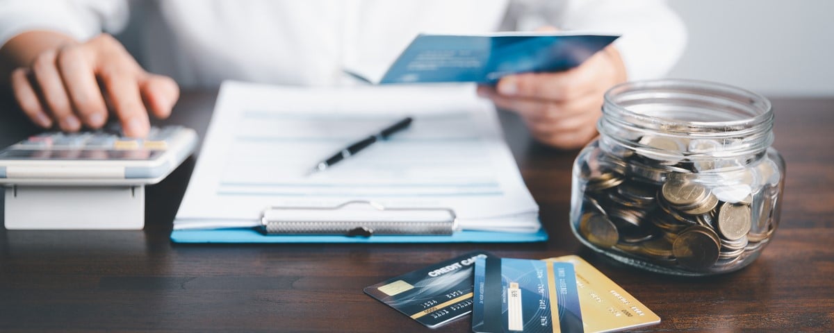 Femme d'affaires tenant dans ses mains un livret d'épargne avec une calculatrice, concept de compte et d'épargne.