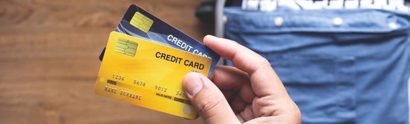 Jeune personne utilisant des cartes de crédit pour payer un voyage de vacances ou de villégiature
